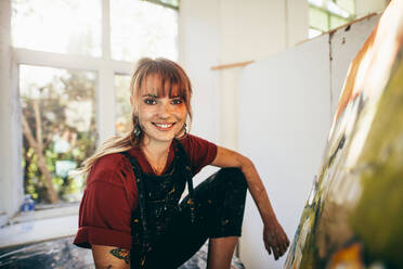 Innenaufnahme einer professionellen Malerin im Atelier, die in ihrem Atelier ein Bild auf Leinwand malt. - JLPSF27322