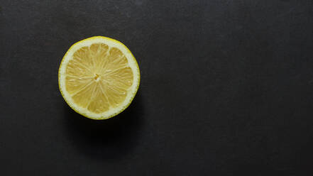 Draufsicht auf eine halbierte Zitrone auf schwarzem Hintergrund. - JLPSF27370