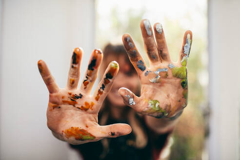 Close up of female artist showing her messy hands. Focus on hands of woman painter with color. - JLPSF27438