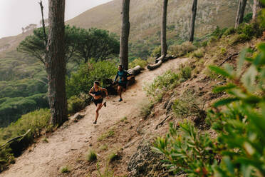 Ein paar Läufer bei einem Cross-Country-Rennen, ein junger Mann und eine Frau laufen in der Natur, Trailrunning-Training. - JLPSF27461