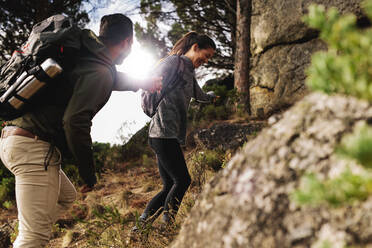 Junge Frau mit ihrem Freund beim Wandern auf einem Bergpfad. Glückliches junges Paar beim gemeinsamen Wandern. - JLPSF27483