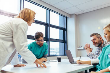 Medical team interacting at a meeting. Medical staff meeting in conference room. - JLPSF27559