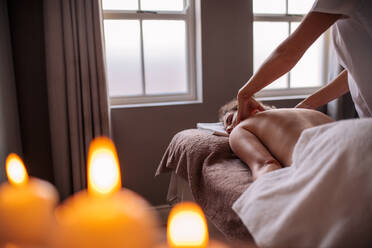 Professional beautician massaging females back at spa salon. Woman receiving body massage to health spa. - JLPSF27584