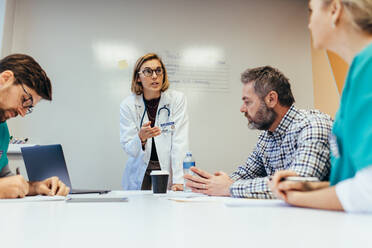 Woman empowerment. Female doctor leading a meeting with her staff in boardroom. Woman medical professional briefing her colleagues. - JLPSF27655