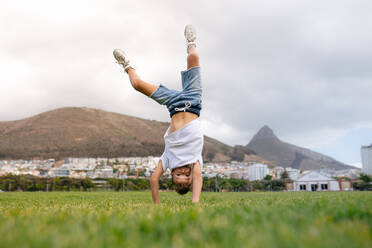 Boy balancing on hands in upside down position in a ground. Boy playing acrobatically in a ground. - JLPSF27693