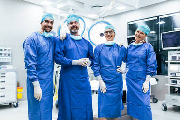 Porträt von erfolgreichen medizinischen Mitarbeitern in chirurgischer Uniform im Operationssaal. Team von Chirurgen steht im Operationssaal, bereit für die nächste Operation. - JLPSF27798