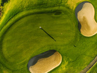 Luftaufnahme von Spielern auf einem grünen Golfplatz. Golfer spielen auf dem Putting Green an einem Sommertag. - JLPSF27803