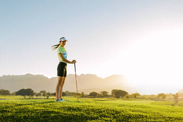 Voller Länge der kaukasischen Golferin stehend auf Golfplatz. Frau spielt Golf auf Feld an einem sonnigen Tag. - JLPSF27826