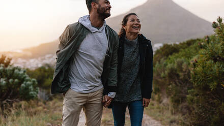 Portrait eines lächelnden jungen Paares auf einem Wanderweg. Glücklicher junger Mann und Frau wandern in der Natur und lächeln. - JLPSF27856