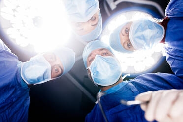 POV shot of surgeons under surgery lights in operating theatre. Medicine professionals performing dental surgery in hospital. - JLPSF27874