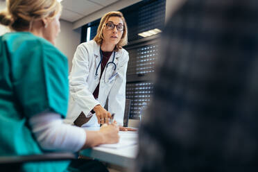 Ärztin informiert ihr Team während einer Besprechung. Besprechung des medizinischen Personals im Krankenhaus. - JLPSF27896