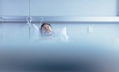 Älterer kranker männlicher Patient, der im Krankenhausbett schläft und auf seine Genesung in der Krankenstation wartet. - JLPSF27897