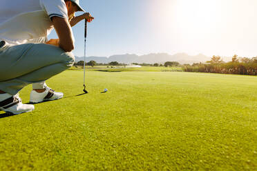 Profi-Golfspieler, der mit dem Schläger auf dem Golfplatz zielt. Männlicher Golfer auf dem Putting-Green, der den Schlag ausführen will. - JLPSF27956