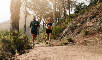 Junge Leute beim Trailrunning auf einem Bergpfad. Zwei Läufer trainieren am Morgen. - JLPSF27991
