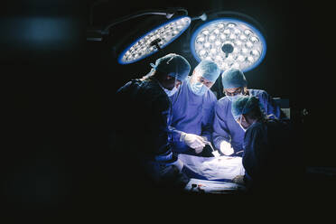 Eine Gruppe von Chirurgen im Operationssaal eines Krankenhauses. Ein medizinisches Team führt eine Operation im Operationssaal durch. - JLPSF28029