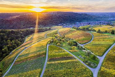 Deutschland, Baden-Württemberg, Drohnenansicht von Stadt und Weinbergen im Remstal bei Sonnenuntergang - STSF03596