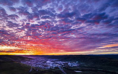 Germany, Baden-Wurttemberg, Drone view of town in Remstal valley at dramatic sunrise - STSF03615