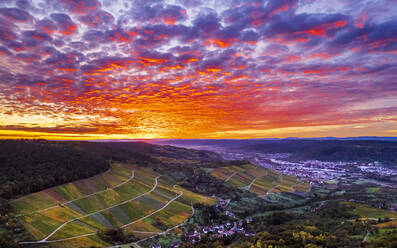 Germany, Baden-Wurttemberg, Drone view of town and vineyards in Remstal valley at dramatic sunrise - STSF03616