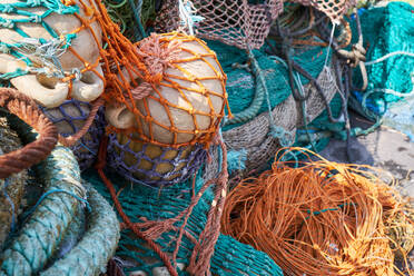 Bündel von bunten Fischernetzen tagsüber im Hafen - ADSF40213