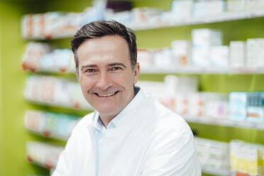 Happy mature pharmacist in pharmacy - JOSEF14576