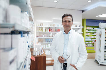 Man in lab coat holding stethoscope in pharmacy - JOSEF14590