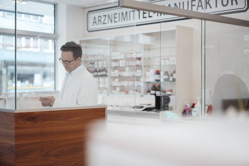 Apotheker prüft Checkliste im Geschäft - JOSEF14600