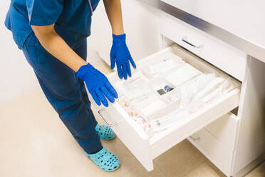 Nurse taking inventory and restocking medical supplies at hospital - MMPF00438
