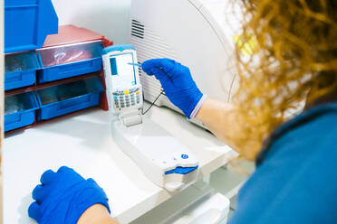 Nurse analyzing blood sample with equipment in laboratory - MMPF00440