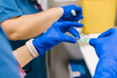 Hände einer Krankenschwester bei der Vorbereitung einer Spritze im Krankenhaus - MMPF00449
