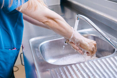 Krankenschwester wäscht sich die Hände mit Wasser im Waschbecken eines Krankenhauses - MMPF00457