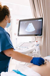 Mature nurse examining patient through ultrasound machine - MMPF00466