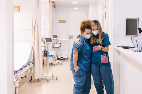 Zufriedene Krankenschwestern nutzen ihr Smartphone im Krankenhaus - MMPF00476