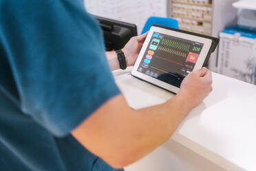 Junge Ärztin prüft Daten auf einem Tablet-PC im Krankenhaus - MMPF00498
