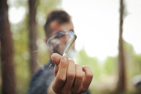 Man with marijuana joint in forest - ACPF01520