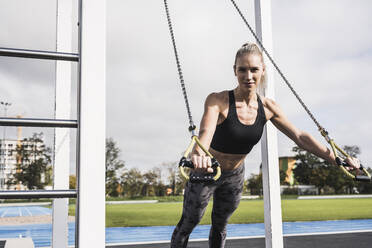 Determined sportswoman exercising at sports track - UUF27742