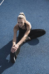 Athlete doing warm up exercise on track - UUF27793