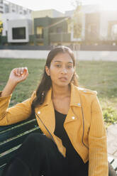 Young woman sitting on bench at park - MEUF08391