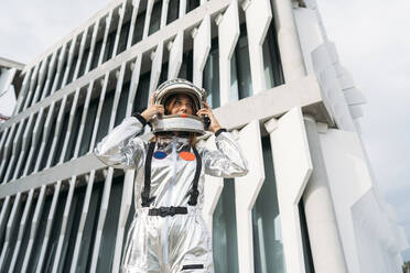 Astronaut mit Weltraumhelm vor einem Gebäude - DAMF01106