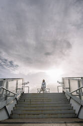 Astronaut mit Weltraumhelm vor einer Treppe stehend - DAMF01107