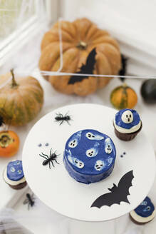 Kürbisse mit Kuchen und Halloween-Dekoration auf dem Tisch zu Hause - ONAF00240
