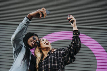 Black friends taking a self portrait on the street - ADSF40284