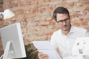 Architekt mit Brille bei der Arbeit im Büro - DHEF00655