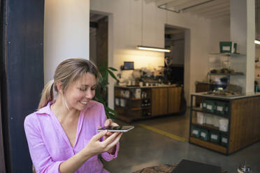 Glücklicher Freiberufler beim Fotografieren mit dem Smartphone im Café - JOSEF14765