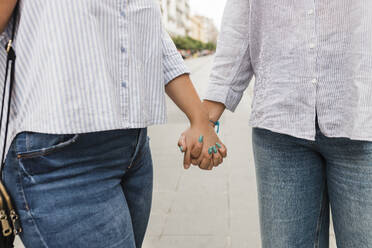 Lesbisches Paar hält Hände auf der Straße - JRVF03262