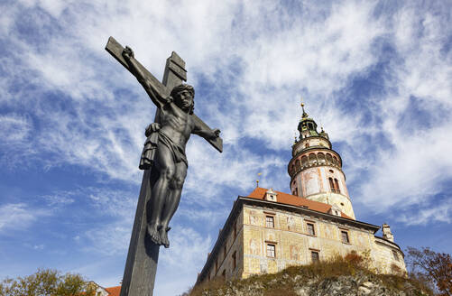 Tschechische Republik, Südböhmische Region, Cesky Krumlov, Skulptur des gekreuzigten Jesus mit Schloss Cesky Krumlov - WWF06258