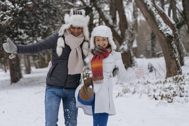 Happy young man with woman playing in snow - OSF01114