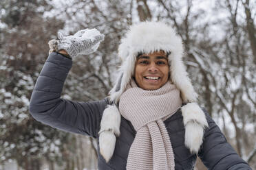 Happy young man playing with snowball - OSF01115