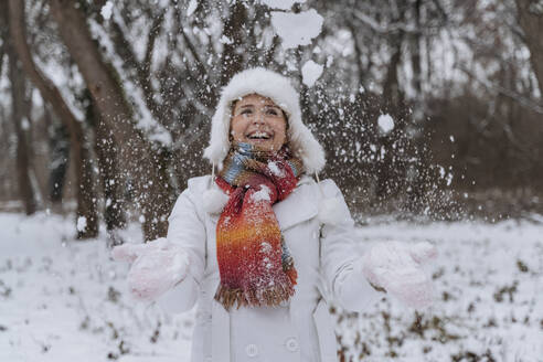 Glückliche Frau spielt mit Schnee im Park - OSF01116