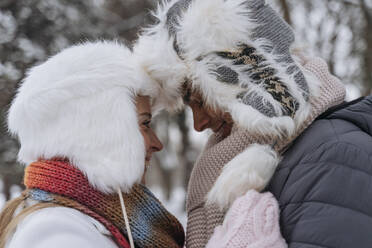 Glückliche Frau umarmt Mann im Winter - OSF01117