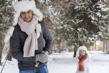 Happy young man with woman standing in background at park - OSF01118